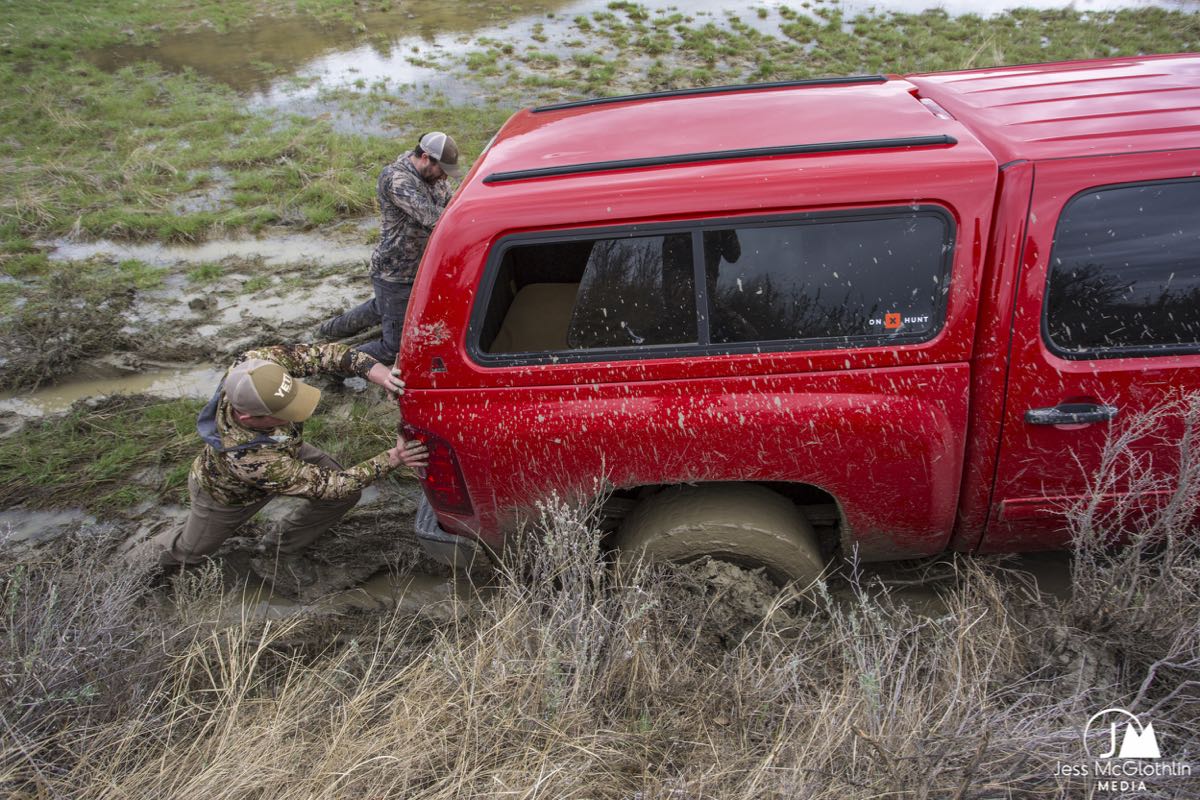Men pushing a truck out of the mud while turkey hunting in Montana. 