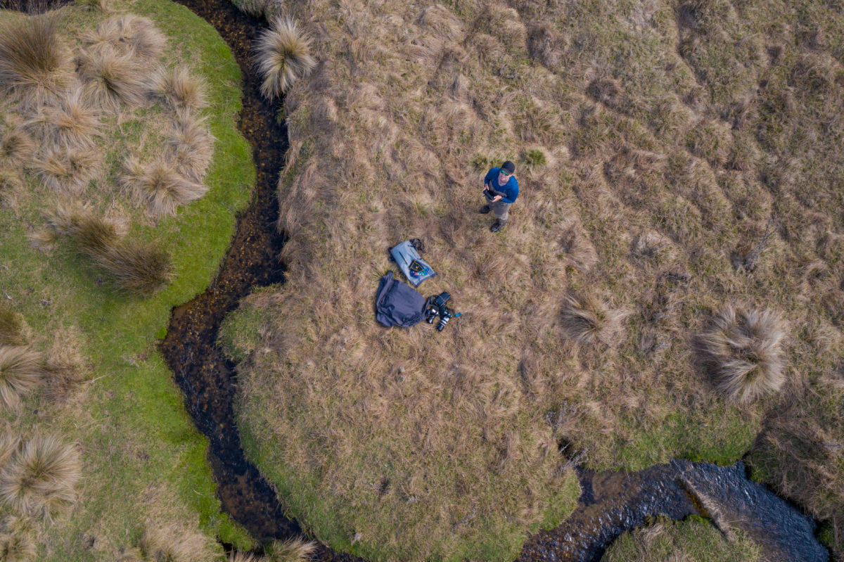 Jess McGlothlin drone image of girl fishing open highland field in Tasmania.