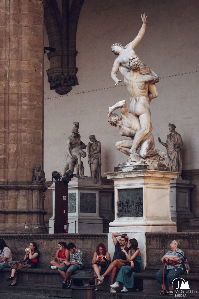 Rape of the Sabine Women statue, photographed at night with people in the Piazza della Signoria in Florence, Italy.